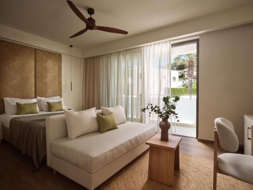 a bedroom with a bed and a couch and a window at Lesante Classic - Preferred Hotels & Resorts in Tsilivi