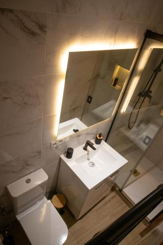 a bathroom with a white sink and a mirror at Roca Loft Maruja - by Allexperiences in Setenil