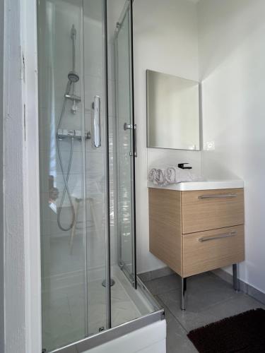 une salle de bain avec une douche en verre et un lavabo dans l'établissement Appartement bord de mer, à La Ciotat