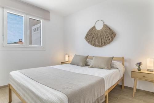 a white bedroom with a bed and a window at La Casita de Álvaro in Conil de la Frontera
