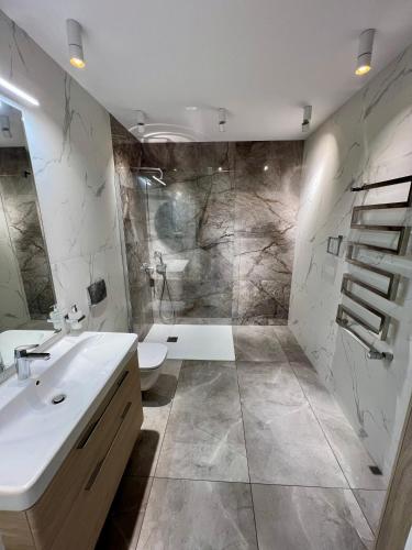 a bathroom with a white sink and a shower at Dworek Żabickie in Żabickie