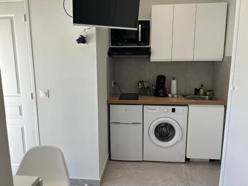 une cuisine avec une machine à laver et un évier dans l'établissement Appartement bord de mer, à La Ciotat