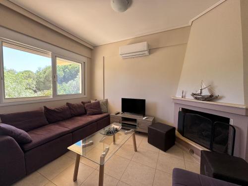 a living room with a couch and a fireplace at Schinias Forest Beach House in Marathón