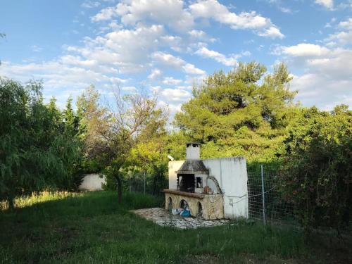 a small brick oven in a yard next to a fence at Schinias Forest Beach House in Marathón