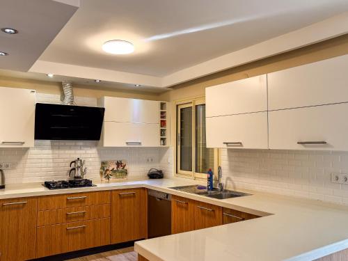 a kitchen with white cabinets and a sink at Villa Kumsal in Kusadası