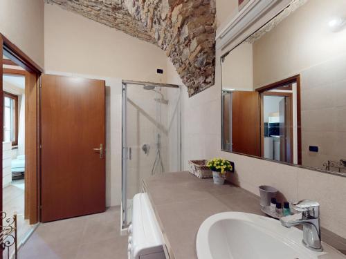 a bathroom with a sink and a mirror and a shower at La Pietra del Garda by Bookinggardalake in Montinelle