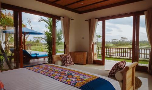 a bedroom with a bed and a balcony at Umah Sunset in Ubud