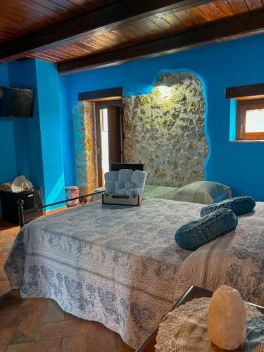 a blue room with a large bed and a chair at Agriturismo Le Faeta in Arpino