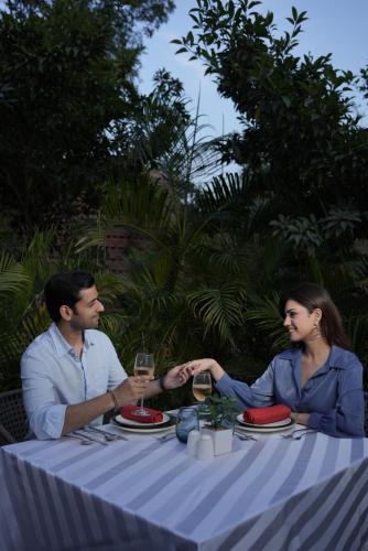 a man and woman sitting at a table with wine glasses at The Westin Sohna Resort & Spa in Gurgaon