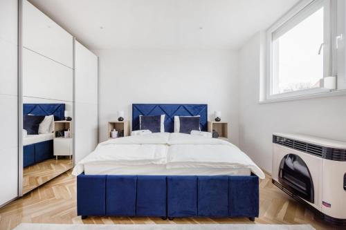 a bedroom with a blue bed and a mirror at Tranquil Hideaway on Gellért Hill with Parking in Budapest