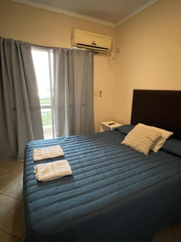 a bedroom with a blue bed with towels on it at FA Temporarios 3 - centro con garage in Corrientes