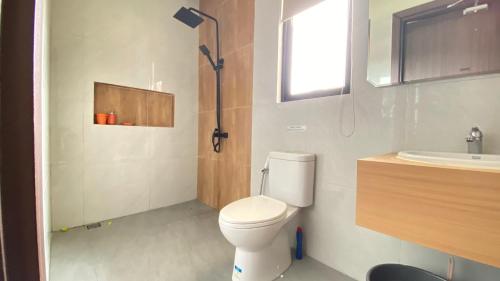 a bathroom with a toilet and a sink at Villa Dwikora Pekanbaru in Pekanbaru