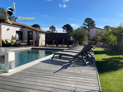 une terrasse en bois avec un banc à côté d'une piscine dans l'établissement Villa Plein pied 8 pers piscine chauffée privée proche plage San Cipriano Cala Rossa Climatisation WIFI, à Lecci
