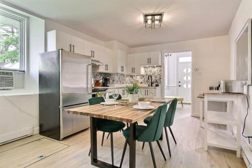 a kitchen with a wooden table and green chairs at 2BR - Hot Tub & 2 Parking - 8 min to Old Quebec in Quebec City
