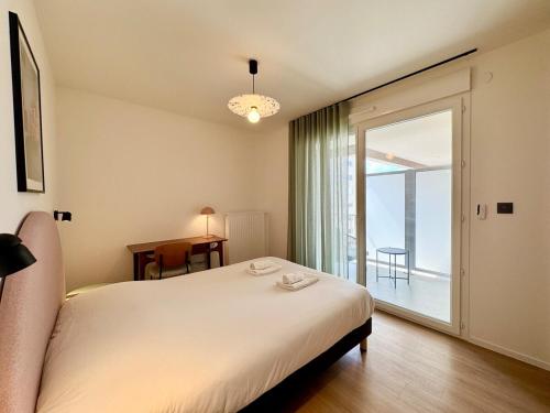 une chambre avec un lit et une grande fenêtre dans l'établissement We Live Inn Sharies Reims A301, à Reims