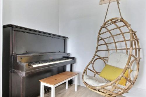 a swinging chair in front of a piano at 2BR - Hot Tub & 2 Parking - 8 min to Old Quebec in Quebec City