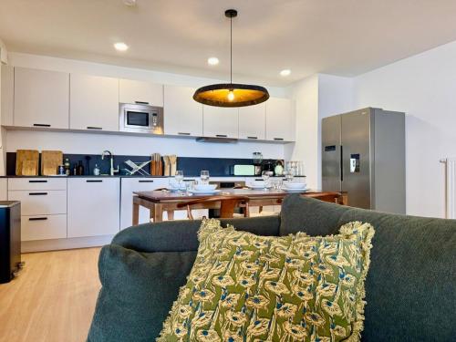 un salon avec un canapé et une cuisine dans l'établissement We Live Inn Sharies Reims A301, à Reims