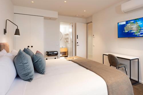 a bedroom with a white bed with a tv on the wall at Hotel Shree Guru Plaza 3 Minute Walking Distance From New Delhi Railway Station in New Delhi