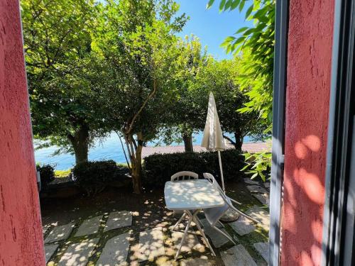 a patio with a chair and an umbrella at Appartamento Punta Movero in Orta San Giulio