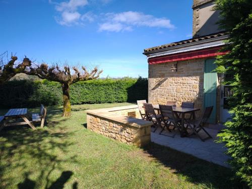 un patio avec une table et des chaises à côté d'un bâtiment dans l'établissement Villa la Salamandre Pool in Sarlat and Montignac, à Sarlat-la-Canéda