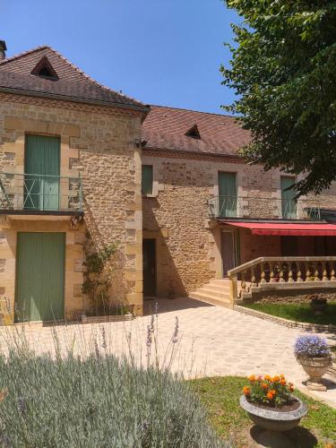 un vieux bâtiment en pierre avec un porche et un patio dans l'établissement Villa la Salamandre Pool in Sarlat and Montignac, à Sarlat-la-Canéda