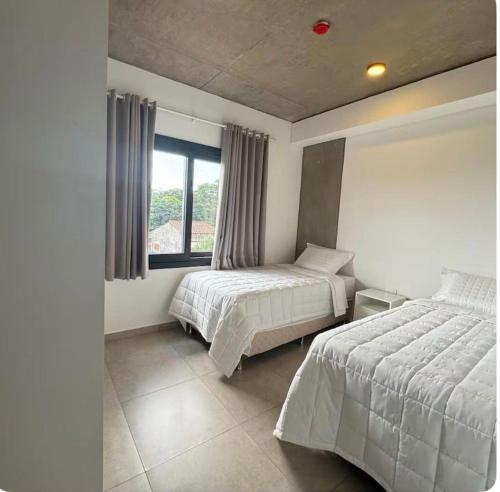 a bedroom with two beds and a window at Departamento con vista al rió 202 in Encarnación