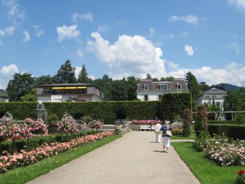 a group of people walking through a garden with flowers at Gästehaus Gerda in Bad Peterstal-Griesbach