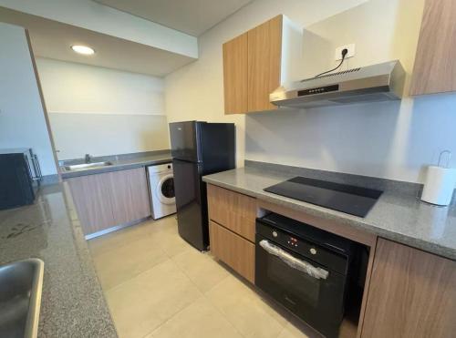 a kitchen with a black refrigerator and a stove top oven at Departamento con vista al rió 202 in Encarnación