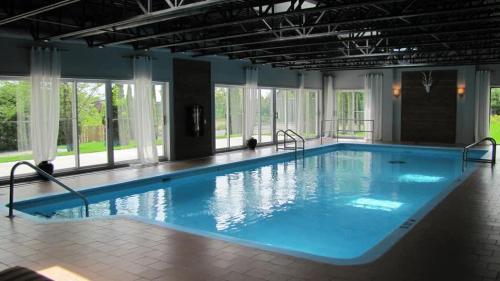 a large indoor swimming pool with blue water at HAPPY HOUR - Condo Water Park in Beaupré