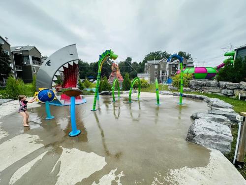 a child is playing in a water park at HAPPY HOUR - Condo Water Park in Beaupré