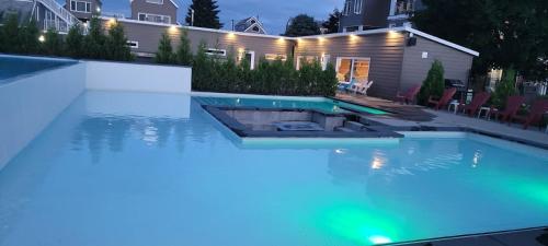 a swimming pool in a backyard at night at HAPPY HOUR - Condo Water Park in Beaupré