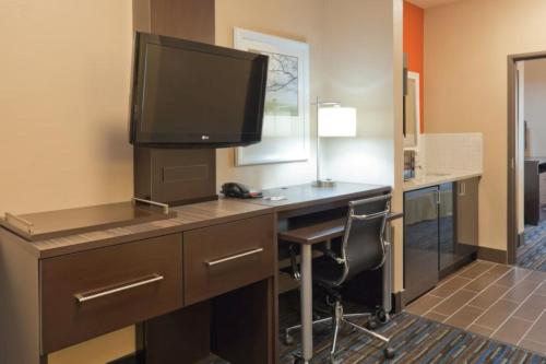 a hotel room with a desk with a television on it at Holiday Inn Express Fulton by IHG in Fulton
