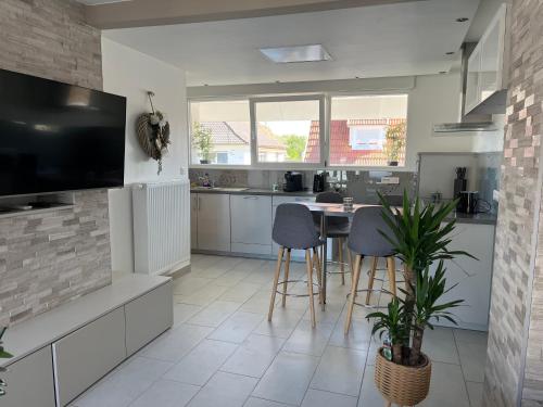 Il comprend une cuisine avec une table et des chaises ainsi qu'une télévision. dans l'établissement Le Coeur Champêtre, à Oberhoffen-sur-Moder