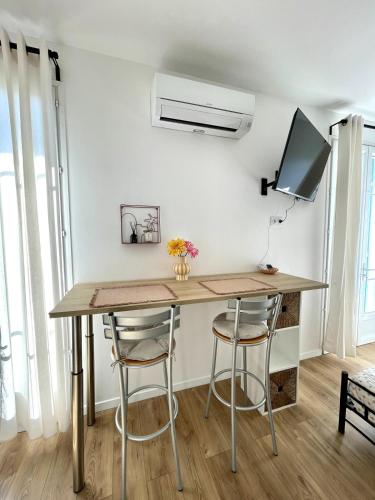 un bureau dans une pièce avec deux tabourets de bar dans l'établissement Studio proche mer, avec terrasse et parking, à Nice