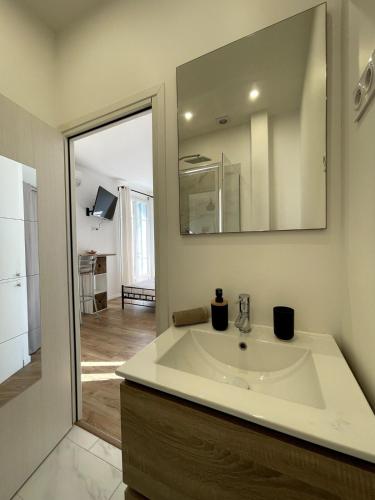 une salle de bain avec un lavabo et un miroir dans l'établissement Studio proche mer, avec terrasse et parking, à Nice