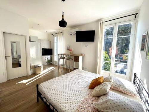 ニースにあるStudio proche mer, avec terrasse et parkingのベッドと大きな窓のある寝室