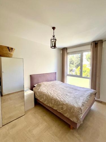 une chambre avec un lit, un miroir et une fenêtre dans l'établissement Charming Flat close to beach, à Cannes