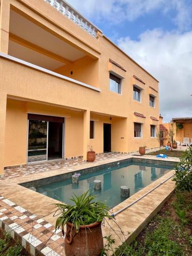 une maison avec une piscine devant dans l'établissement Villa NOUR à Sidi Rahal, à La Celle-sous-Gouzon