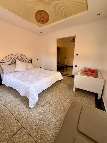 une chambre avec un lit blanc et un tapis roulant dans l'établissement Villa NOUR à Sidi Rahal, à La Celle-sous-Gouzon