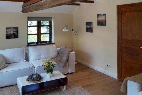 a living room with a white couch and a table at Landhaus zur alten Kastanie in Bohnert