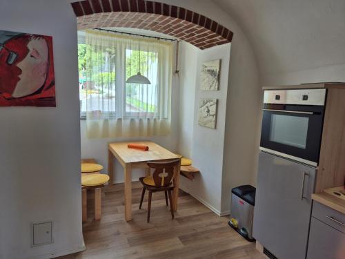a kitchen and dining room with a table and a window at Kühweg Apartments in Hermagor