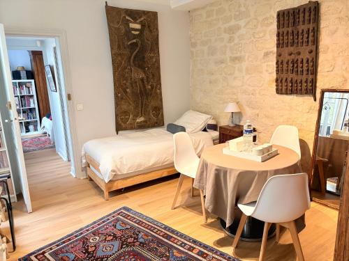 une chambre avec un lit, une table et des chaises dans l'établissement Champs Élysées, à Paris