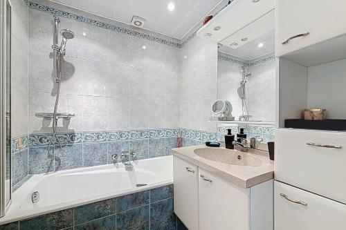 une salle de bain avec une baignoire et un lavabo dans l'établissement Spacious 2-room apartment near Nation, à Paris