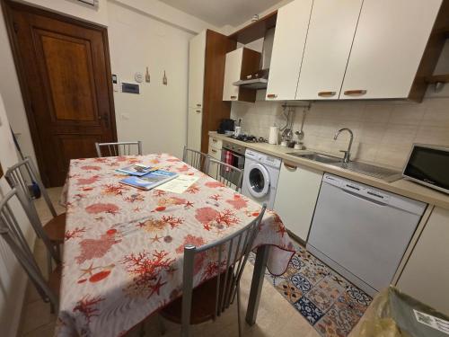 a kitchen with a table and a washing machine at Appartamenti Mondo Per Te in Santa Margherita Ligure
