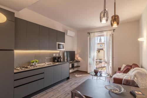 a kitchen with gray cabinets and a table in a room at The Tower Glimpse in Florence