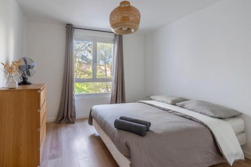 une chambre avec un grand lit et une fenêtre dans l'établissement L'Ovalino, 3 chambres au calme, 100 m2, à Montpellier