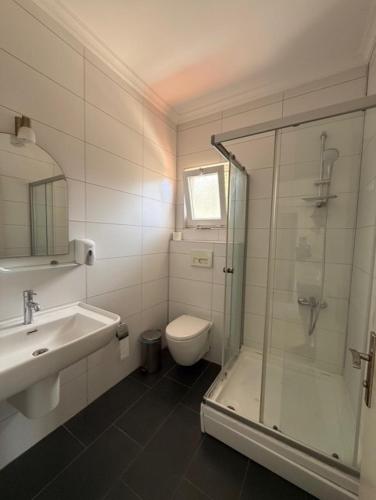 a bathroom with a shower and a toilet and a sink at Lycian Center Hotel in Fethiye