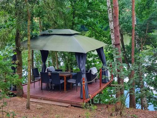 a deck with a table and chairs and a large umbrella at The Hideaway in Želiv