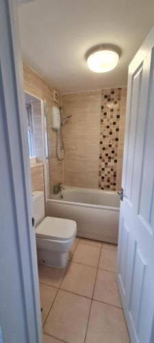 a bathroom with a tub and a toilet and a sink at 4 Bed House - Sleeps 8 - Garden - Parking - Wifi in Gillingham