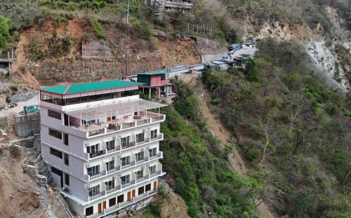 a building on the side of a mountain at Hotel Vedic Alaknanda in Rudraprayāg